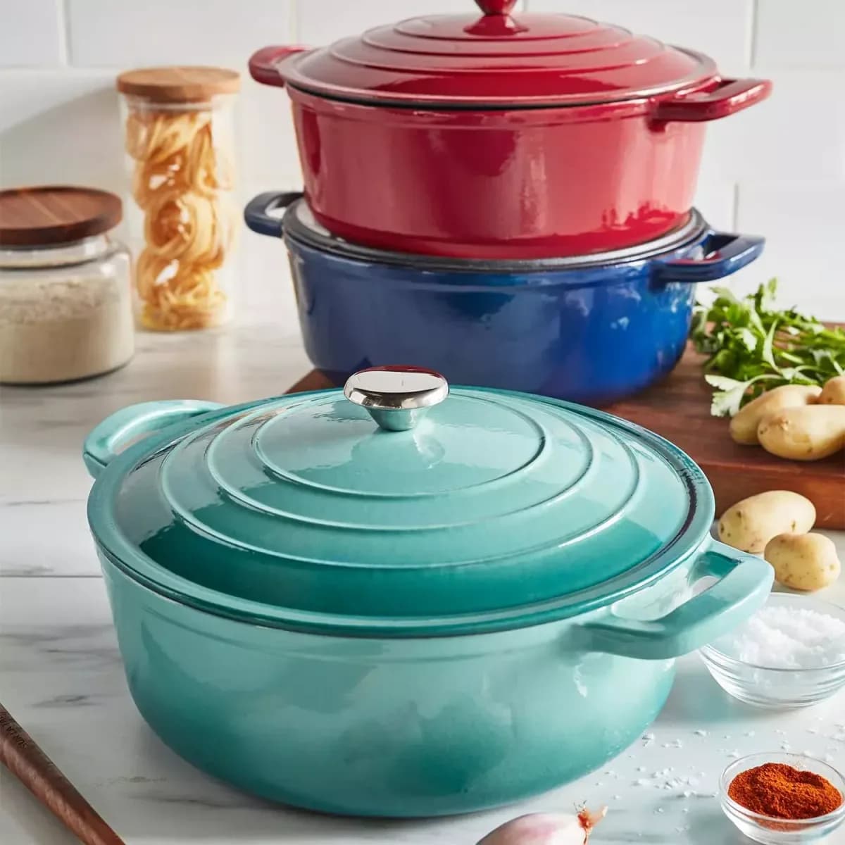 enameled cast iron Dutch ovens with lids in red and blue enamel